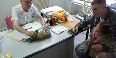 Le médecin anesthésiste montre avec une peluche comment se passera l'anesthésie